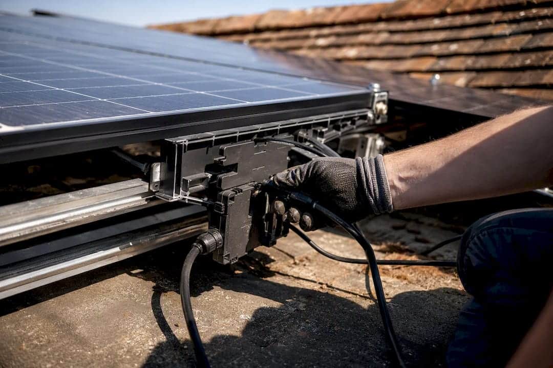 Technician installing microinverter on solar panel