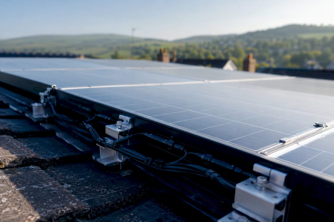 Close-up of wired solar cells within panel on rooftop