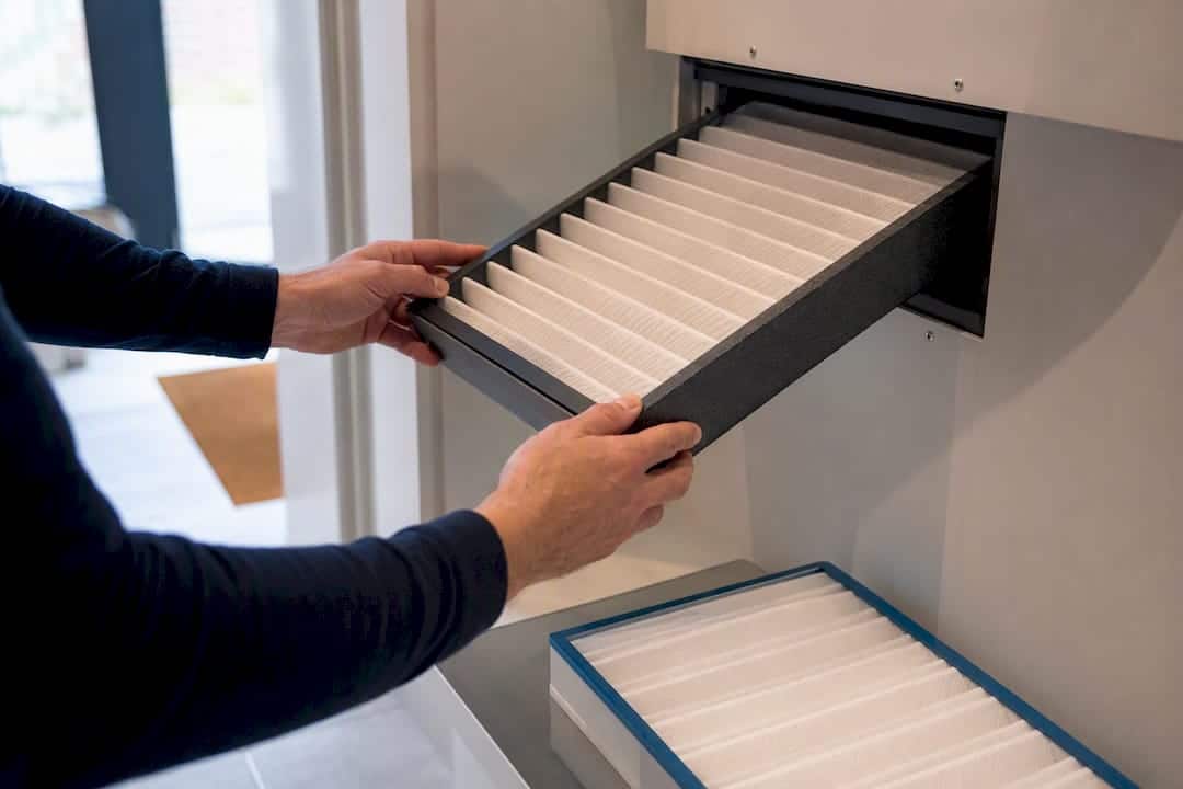 Hands replacing an MVHR ventilation filter