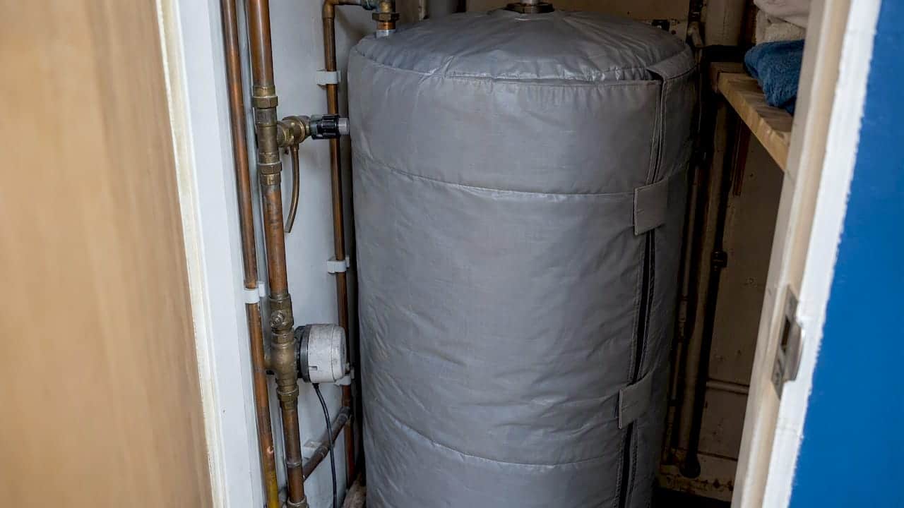 Insulating jacket fitted around a hot water cylinder